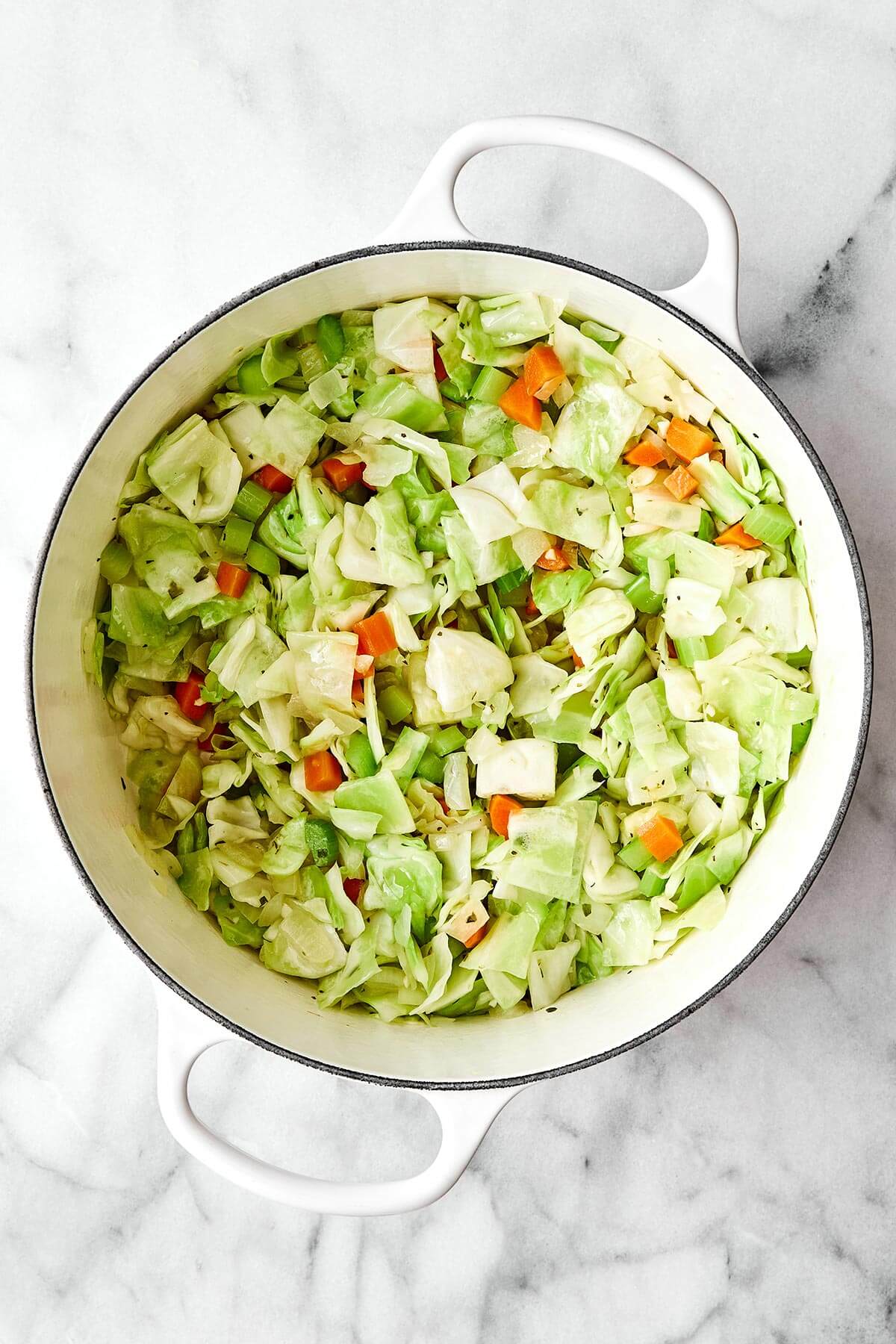 Adding cabbage into a pot.