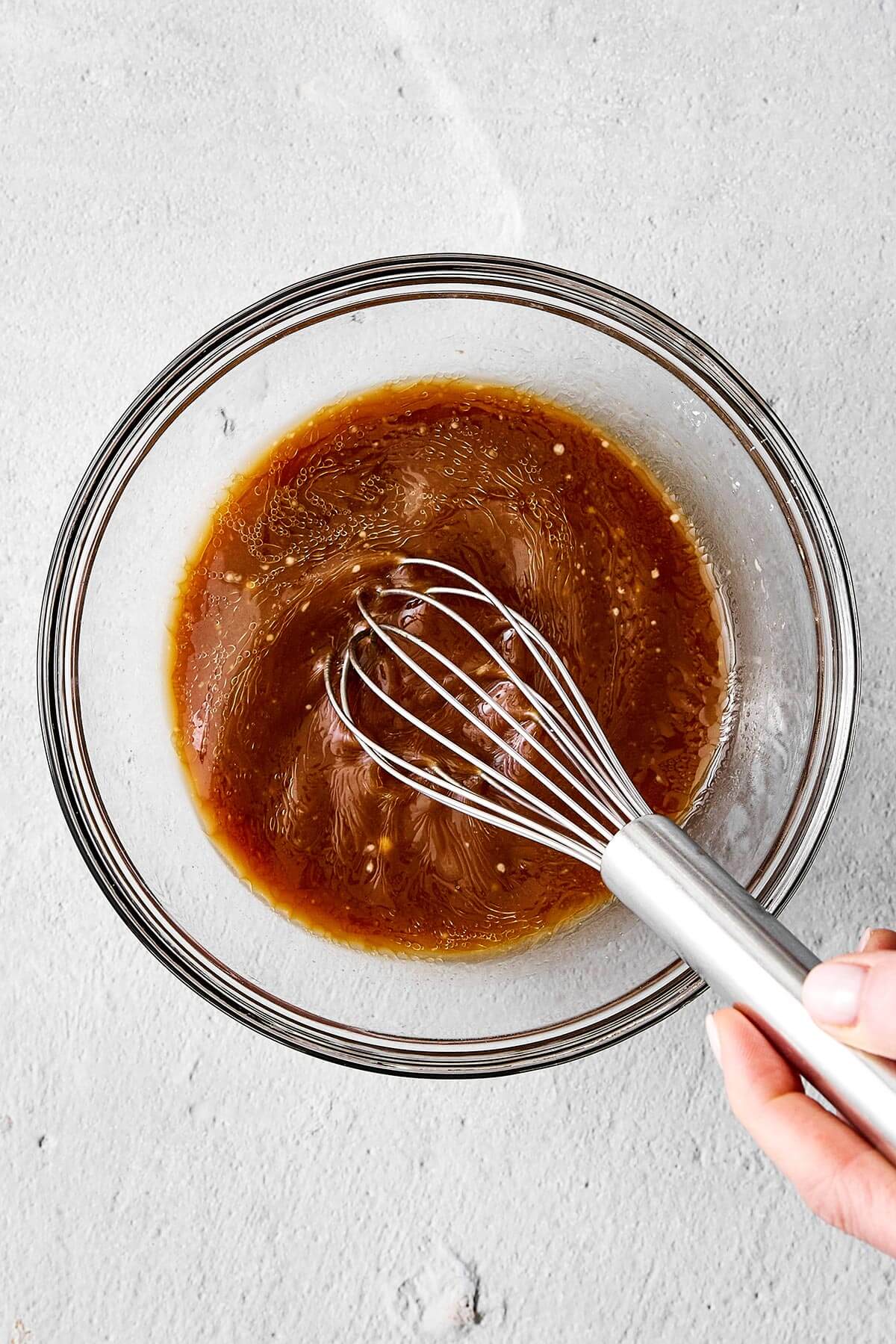 Whisking stir-fry sauce in a bowl.