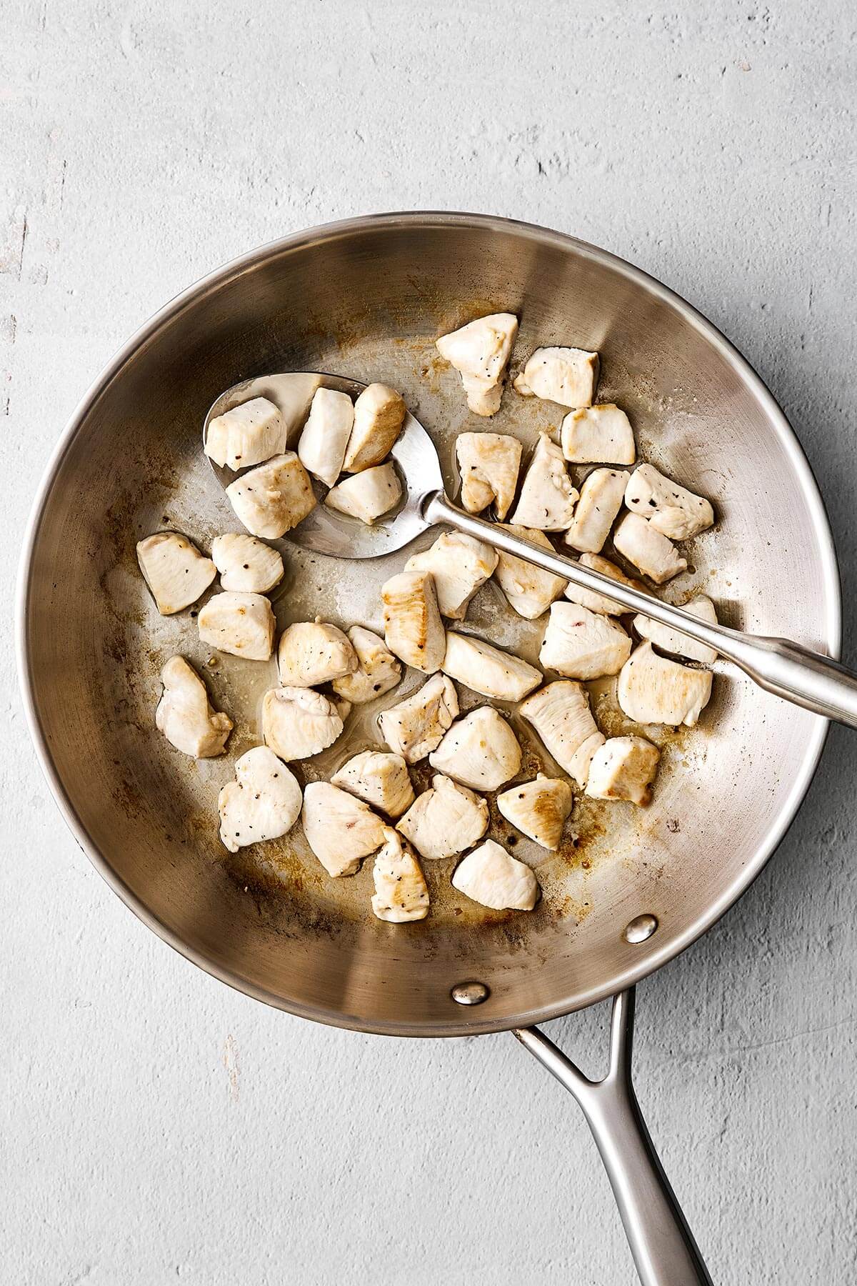 Cooked chicken breast in a pan.