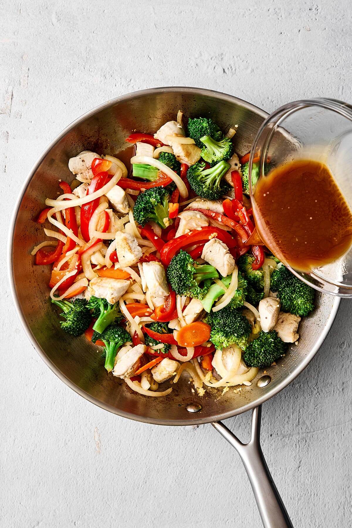 Cooked vegetables and chicken in a pan.