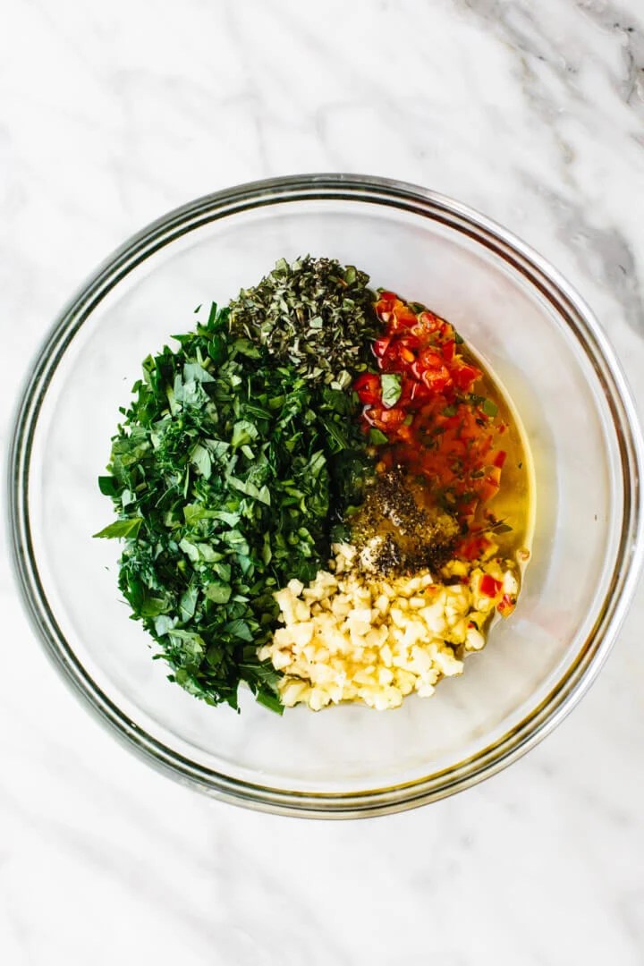 Chimichurri sauce ingredients in a glass bowl