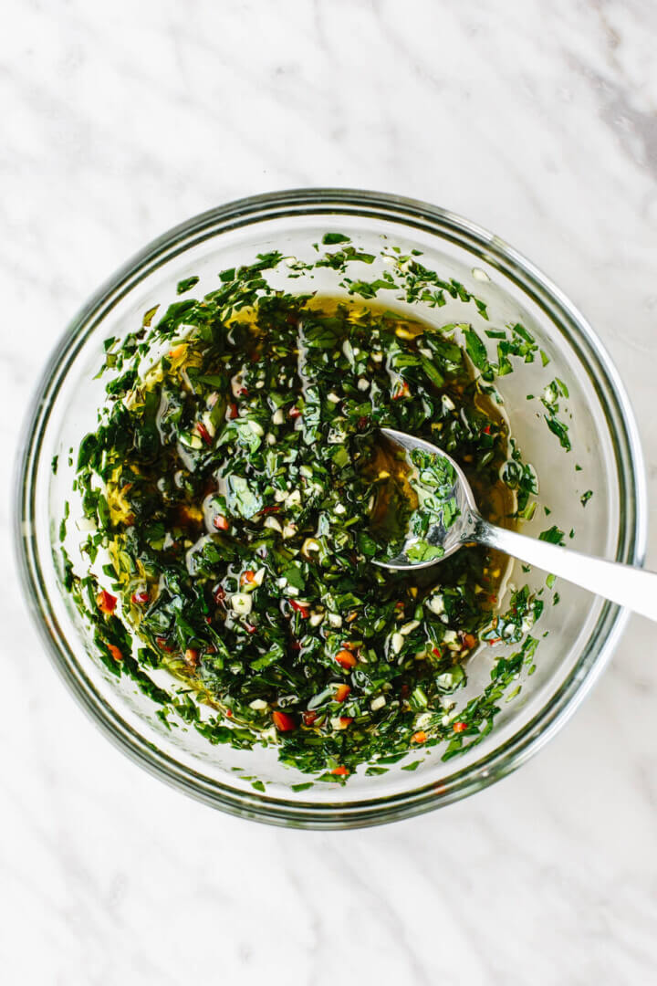 A glass bowl of chimichurri sauce