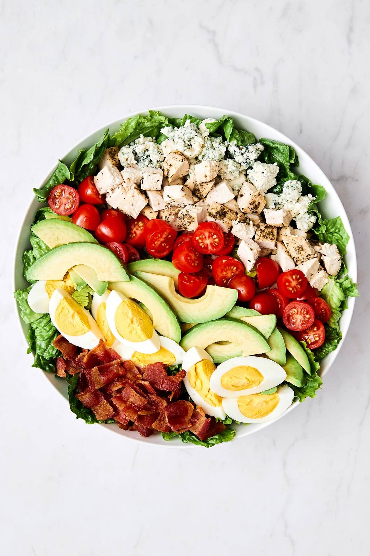 Preparing Cobb salad in a bowl.