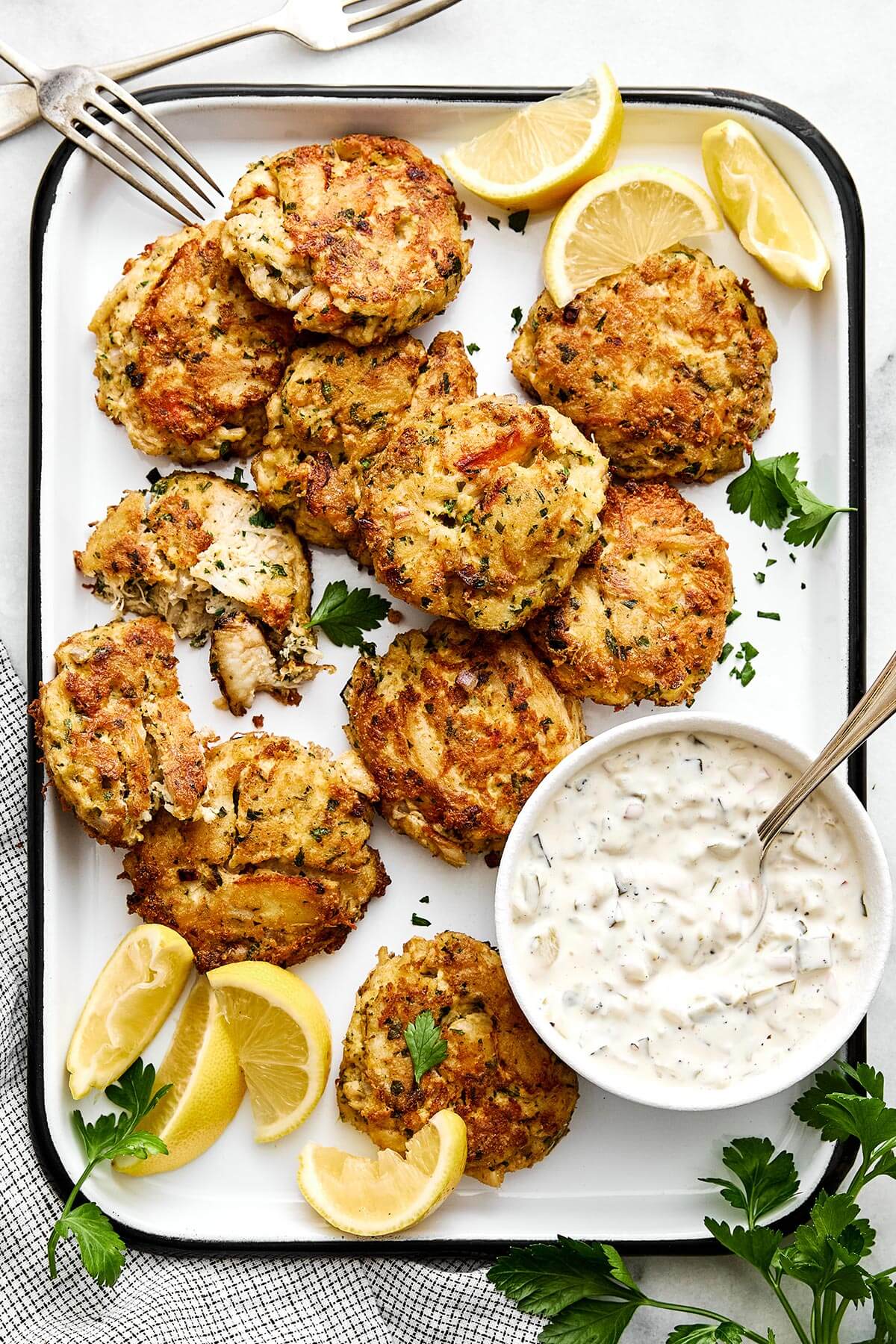 A platter of crab cakes with tartar sauce.