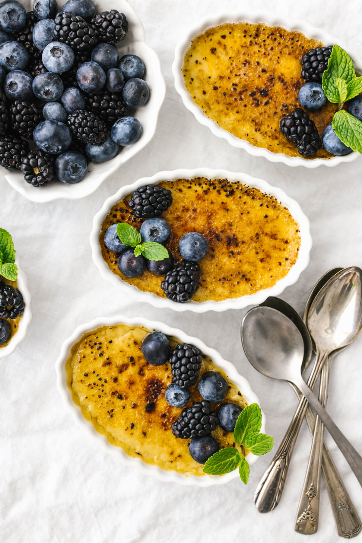 Coconut crème brûlées with berries on top.