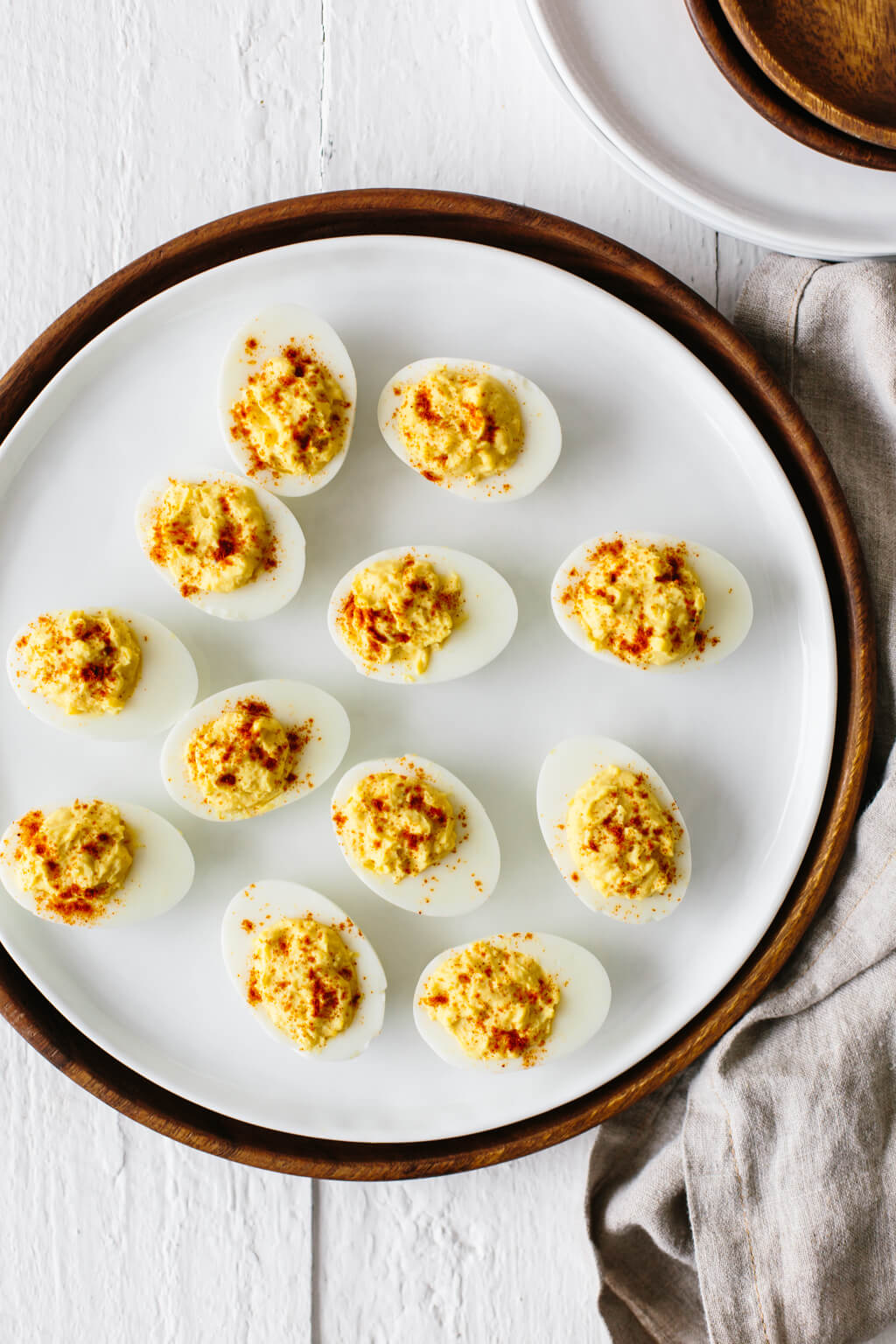 One dozen deviled eggs on a white plate.
