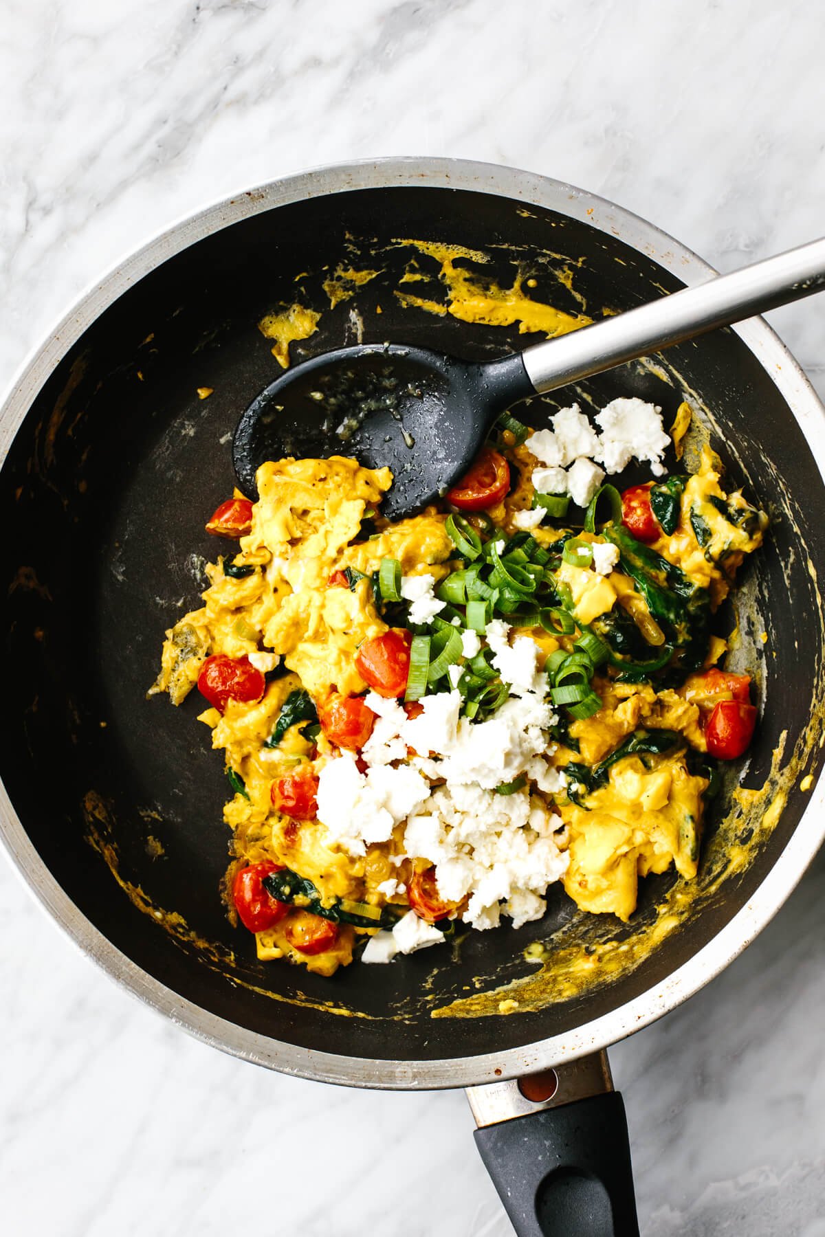 Greek scrambled eggs in a black pan