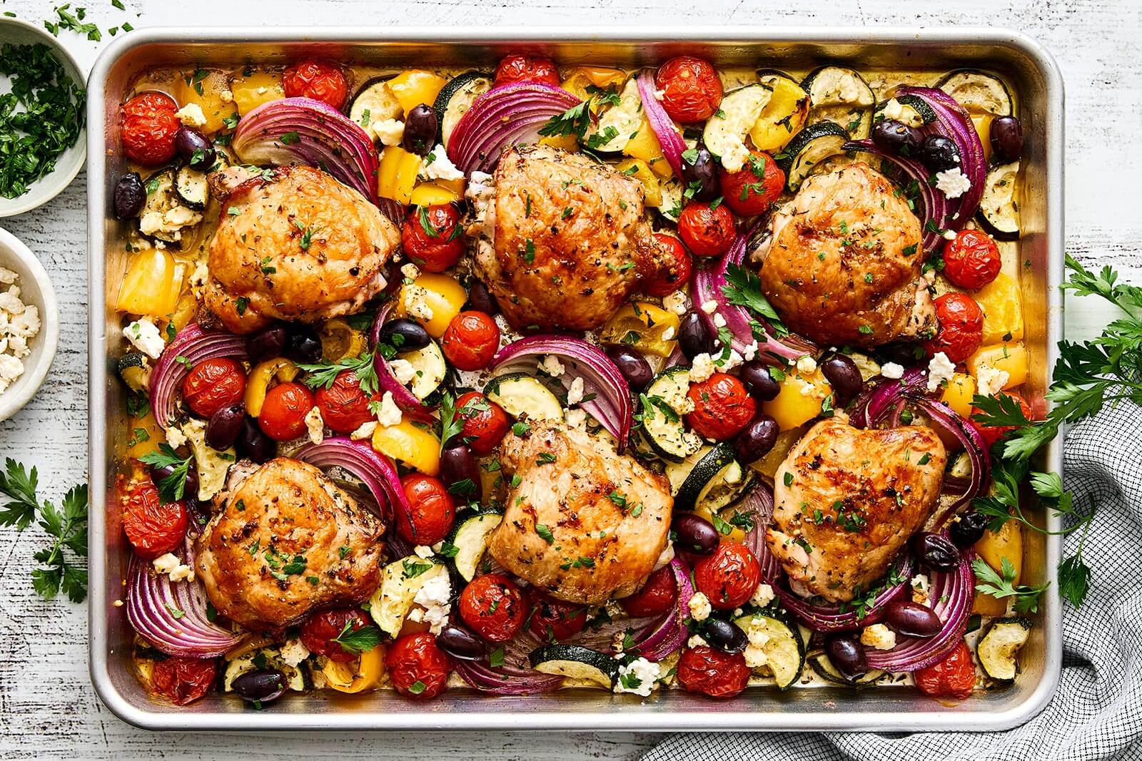 A sheet pan of Greek chicken and vegetables.