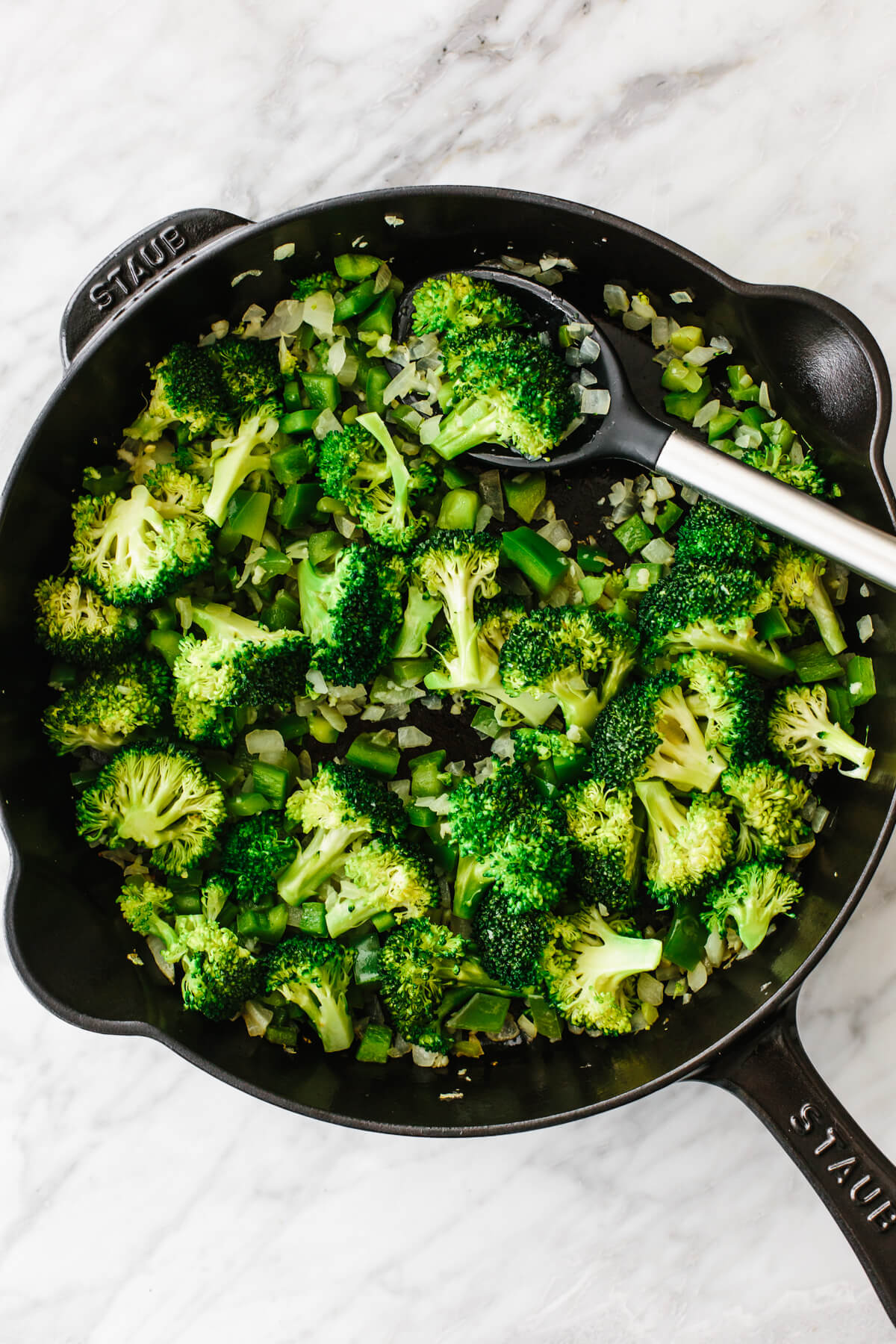 Cooking veggies in a pan for ham and broccoli breakfast casserole