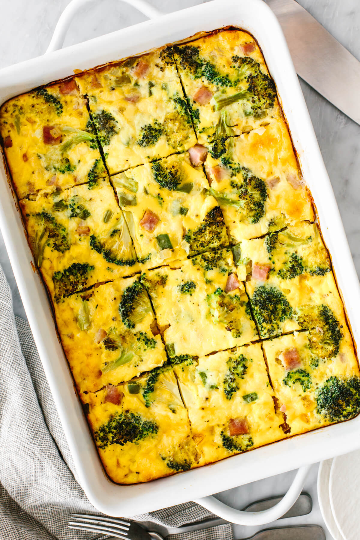 A breakfast casserole next to utensils