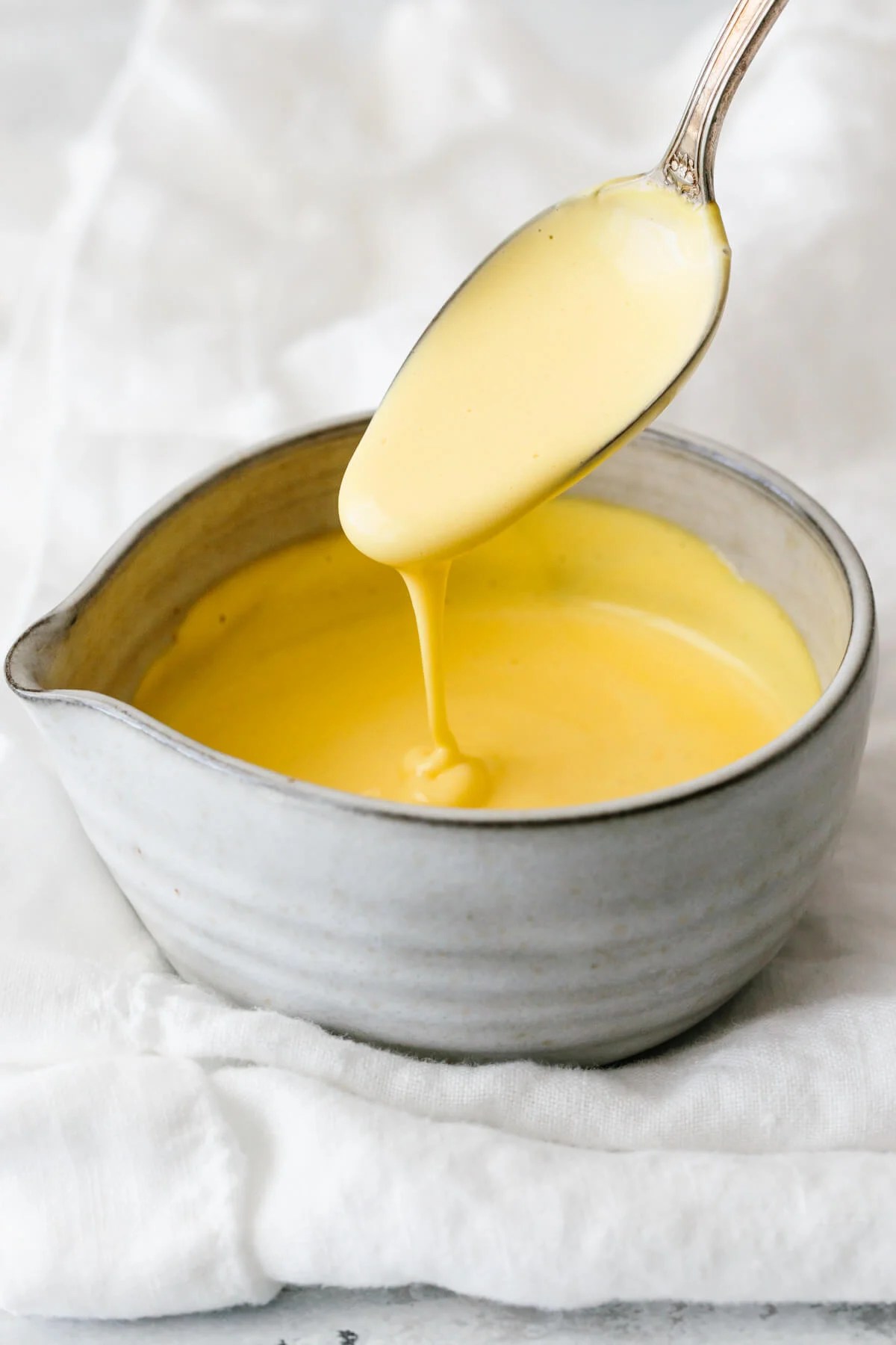 Hollandaise sauce in a small grey bowl.