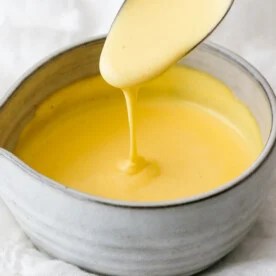 Hollandaise sauce dripping off a spoon.