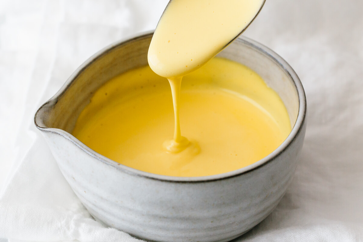 Hollandaise sauce dripping off a spoon.