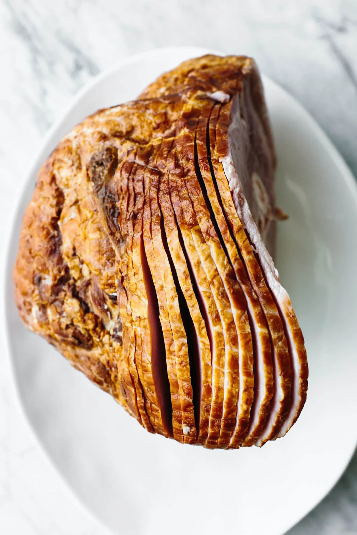 A cooked, honey baked ham on a plate