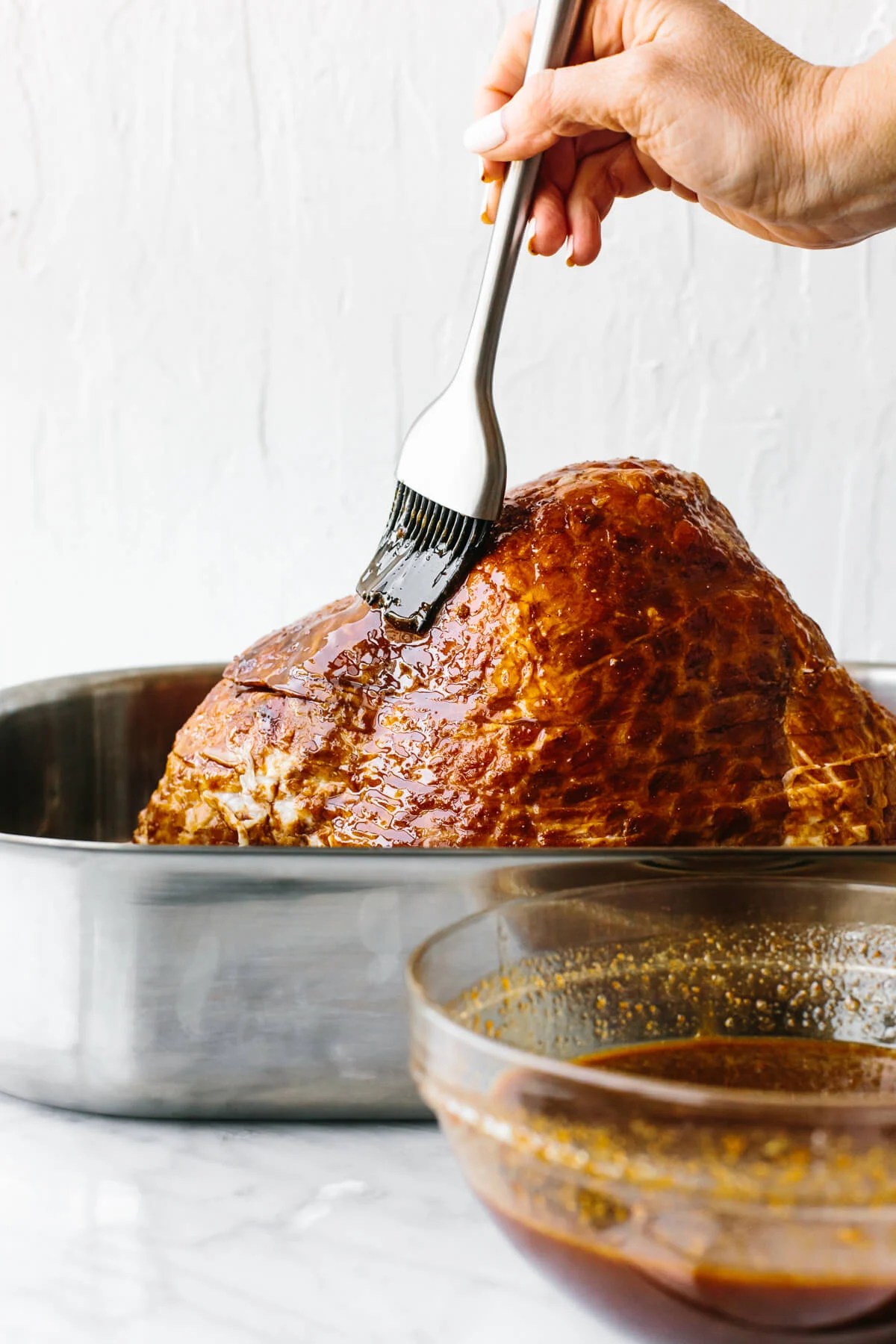 Glazing a ham with a silicone brush.