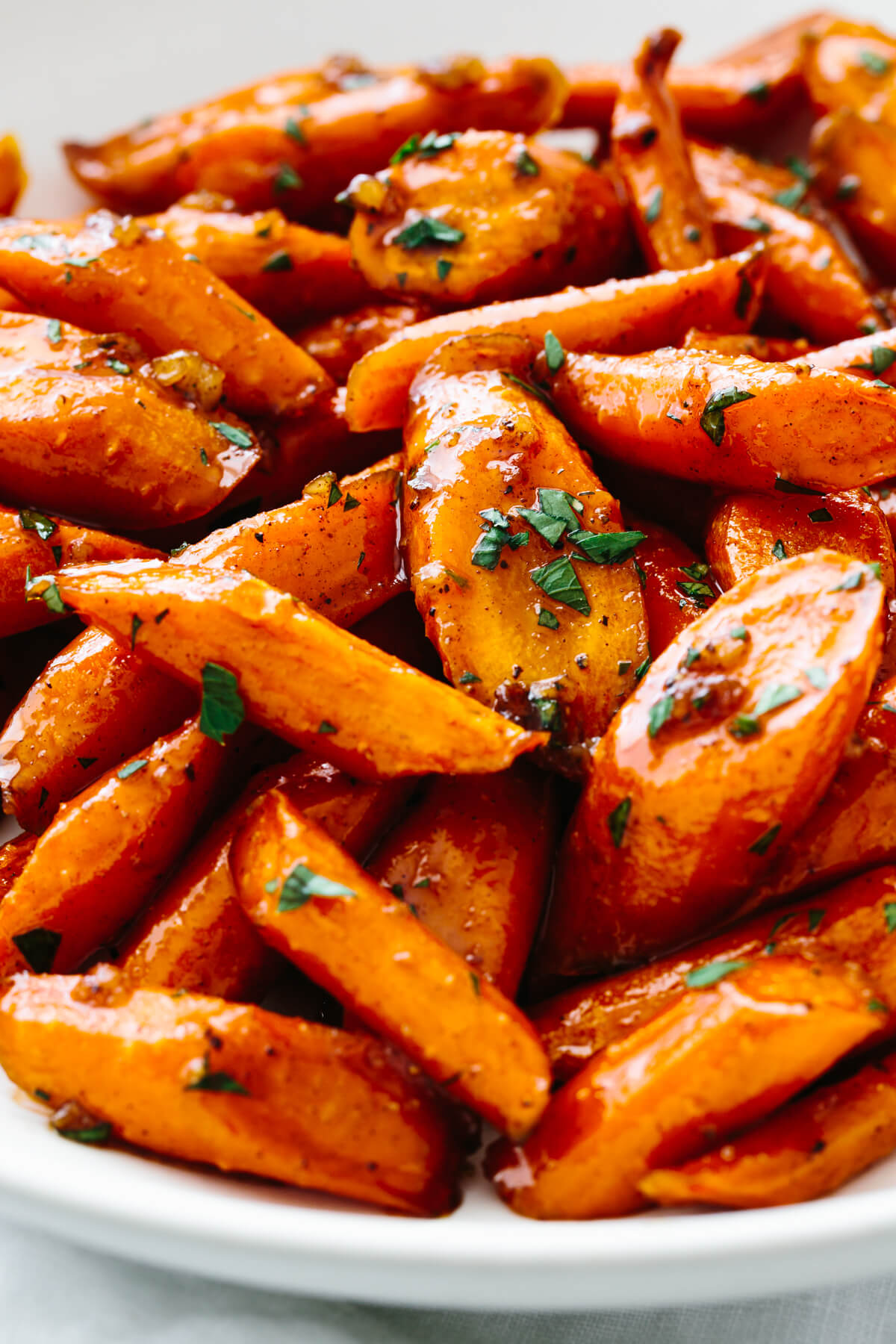 A white bowl with honey glazed carrots.