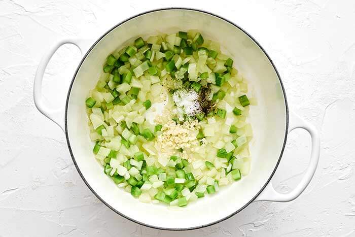 Cooked onions and bell peppers in a pot.