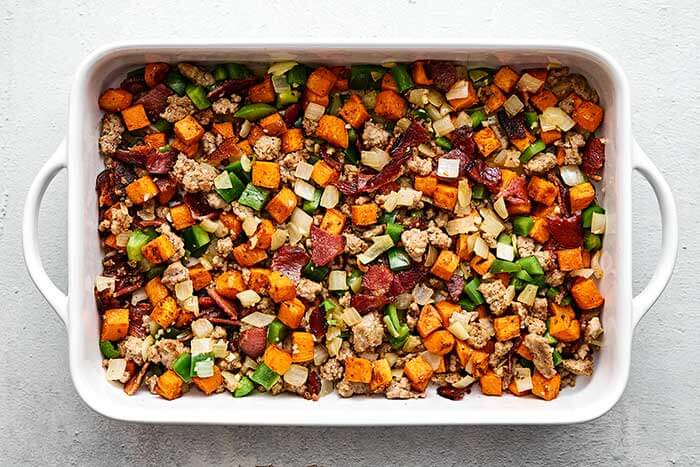 Prepping breakfast casserole in a pan.