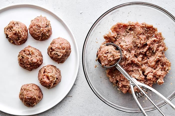 Rolling chicken breakfast sausages into balls.