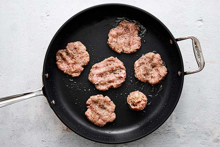 Cooking breakfast sausages in a pan.