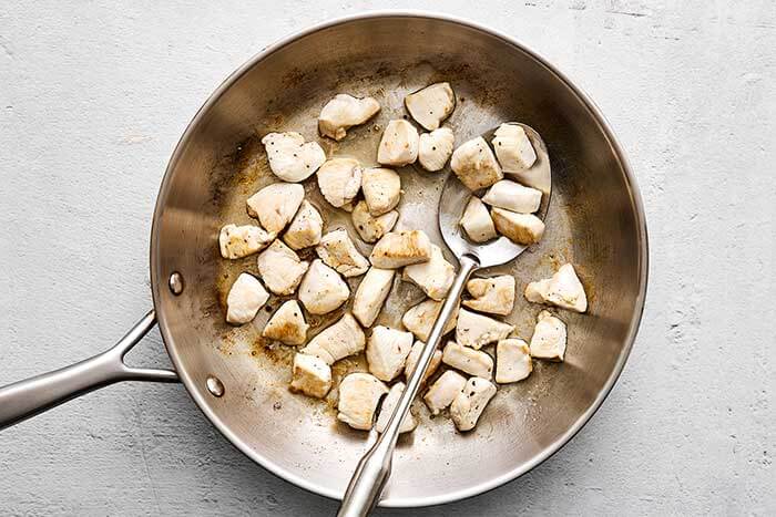 Cooked chicken breast in a pan.