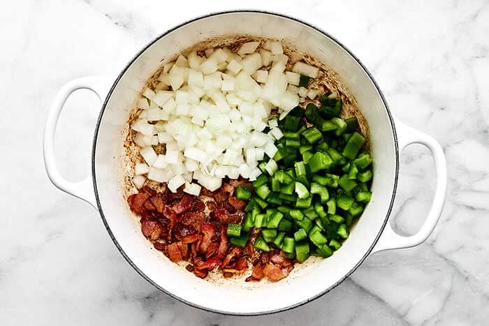 Cooking vegetables and bacon in a pot.