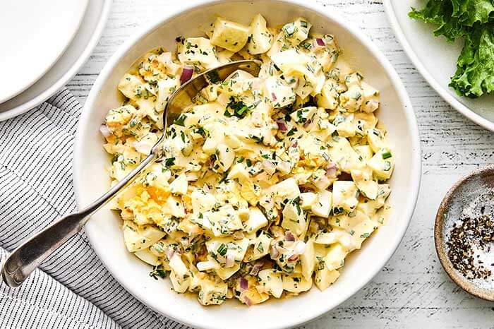 Egg salad in a white bowl.