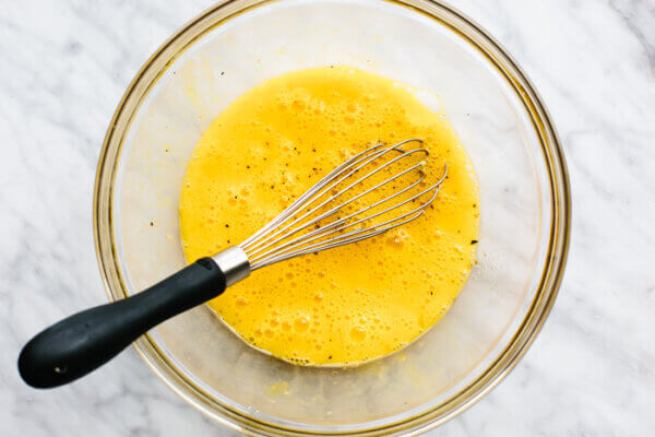 Whisking eggs in bowl for scrambled eggs