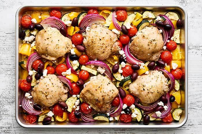 Cooked chicken and vegetables on sheet pan.