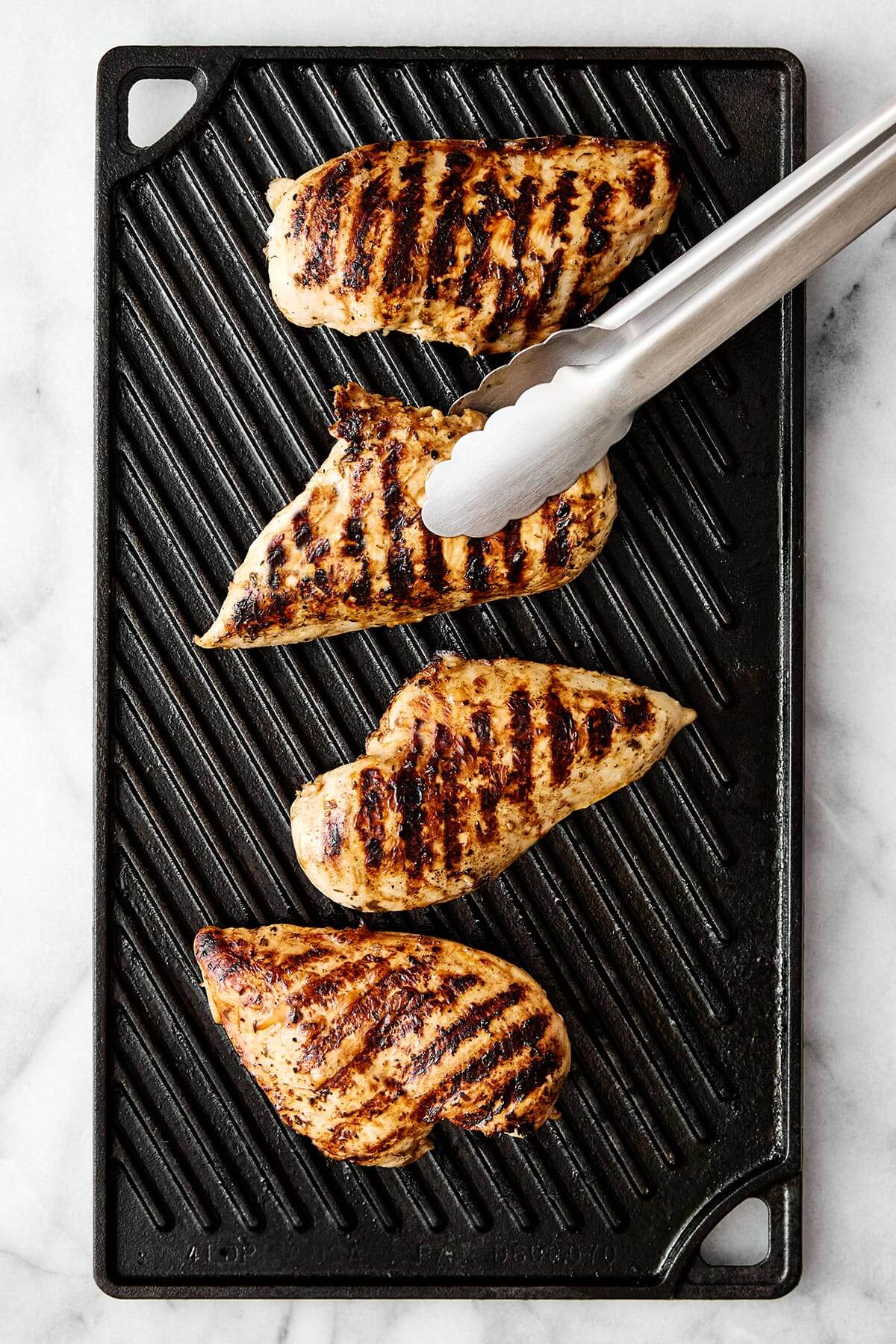 Grilling chicken on a griddle.