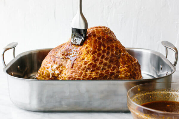 Brushing glaze on a honey baked ham