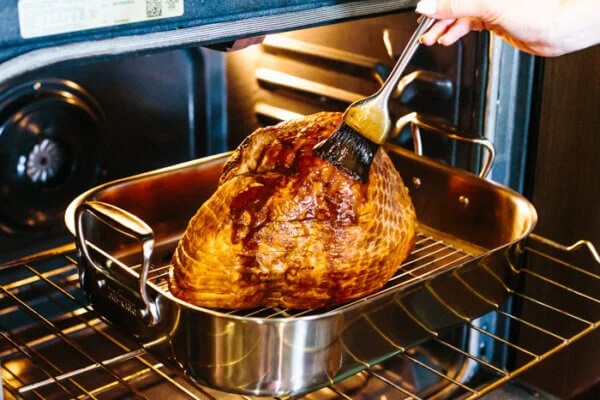 Brushing honey glaze on a honey baked ham