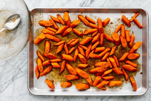 Honey glazed carrots on a sheet pan before baking.