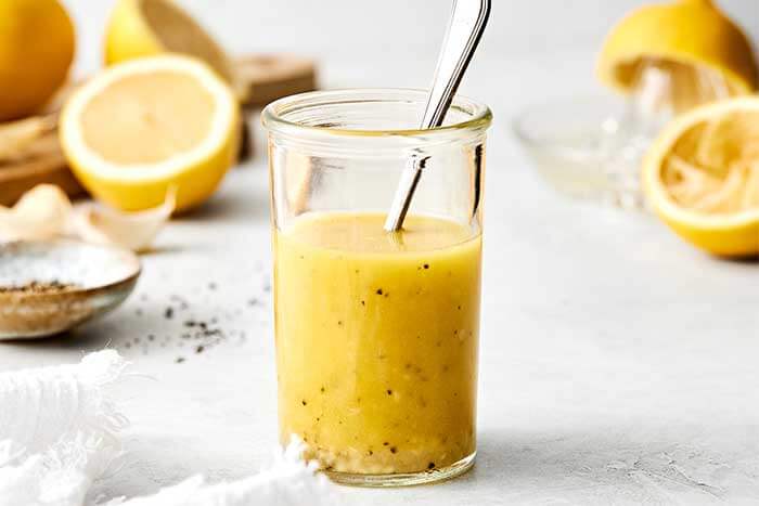 A glass jar of lemon vinaigrette.