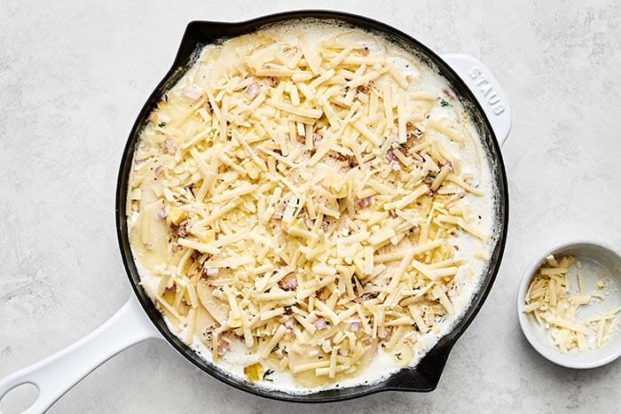 Simmered scalloped potatoes in a pan.