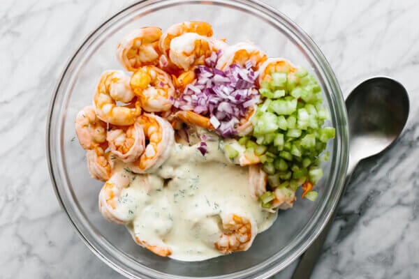 A glass bowl of shrimp salad ingredients