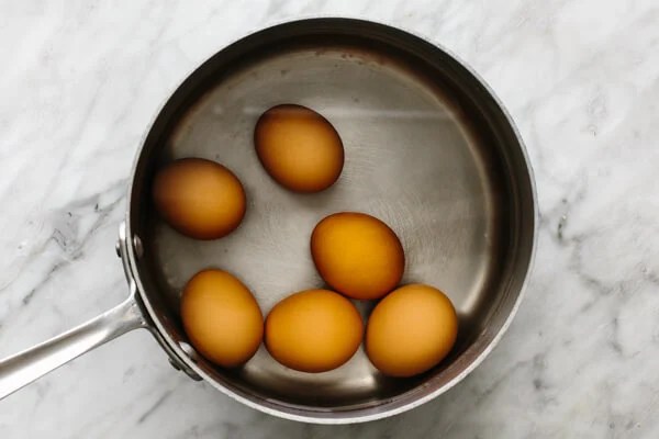 Boiling eggs in a pot for smoked salmon deviled eggs.
