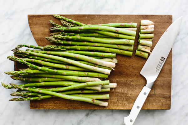 Chopped asparagus on a wooden board for roasted asparagus