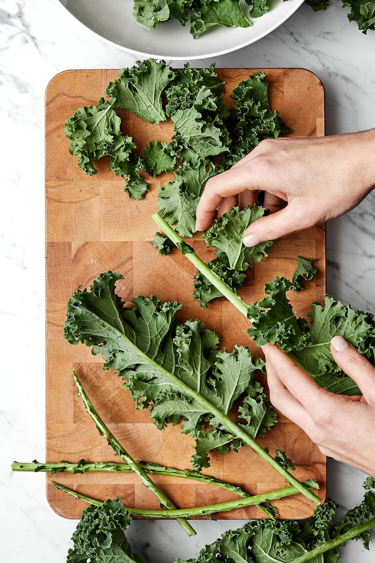 Ripping kale leaves off the stem.