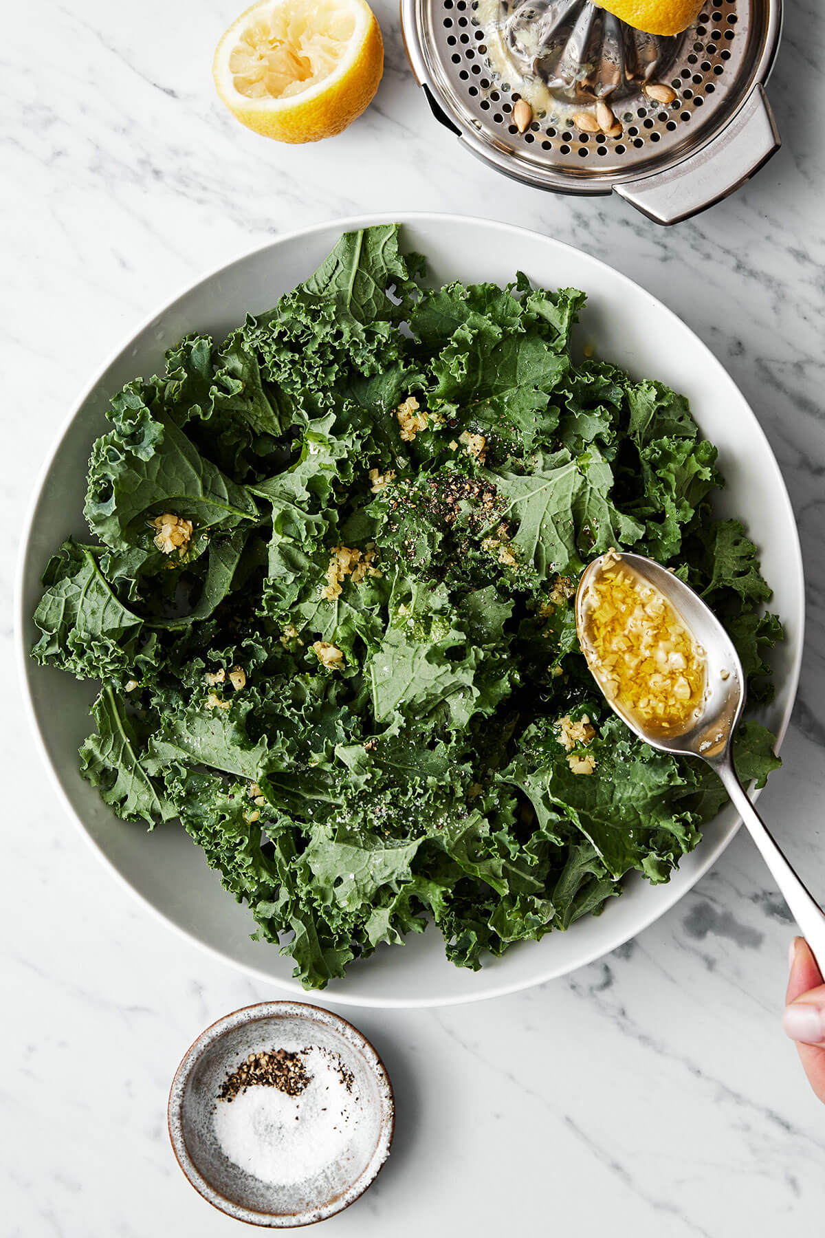 Making kale salad in a bowl.
