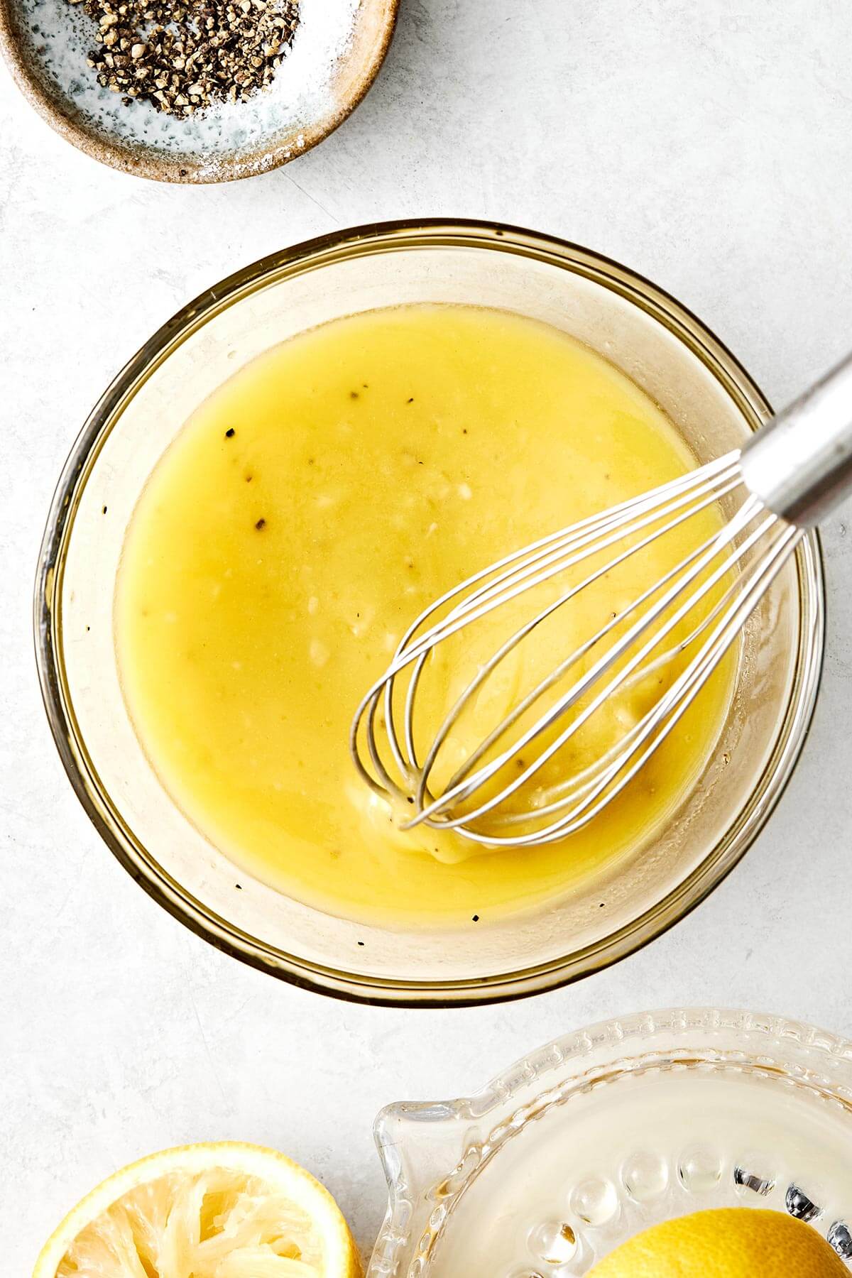 Whisking lemon vinaigrette in a bowl.