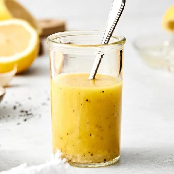 A glass jar of lemon vinaigrette dressing.