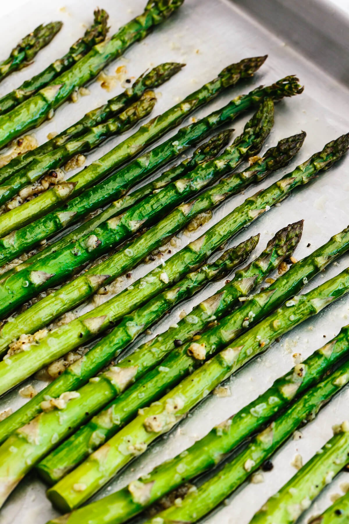 A close up of roasted asparagus on a sheet pan