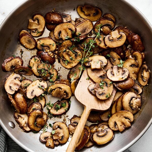 Sauteed mushrooms with thyme in a pan.