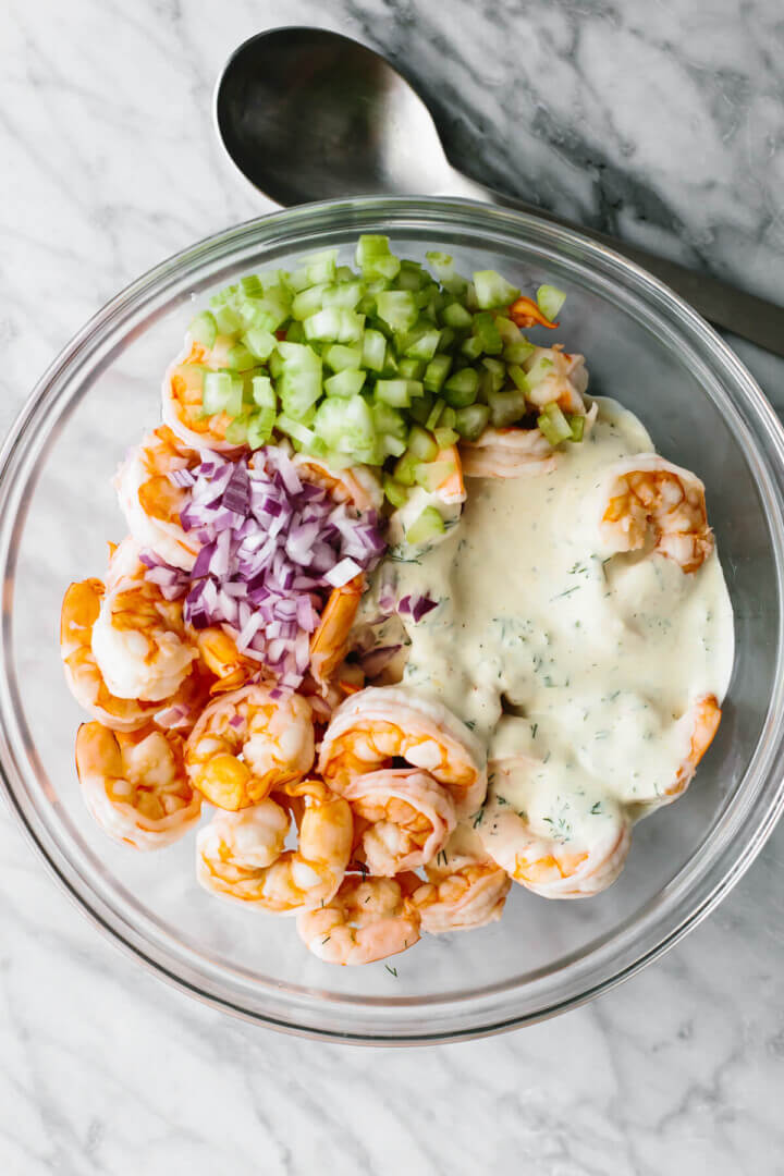 Mixing shrimp salad ingredients in a bowl