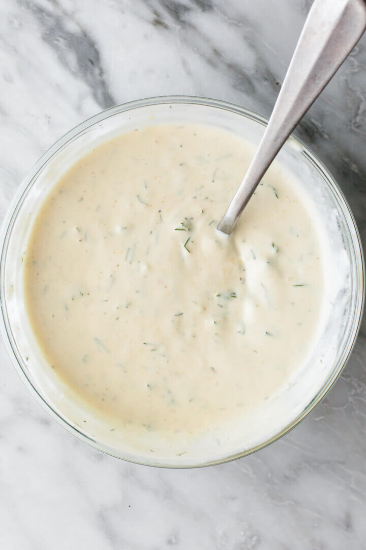 Shrimp salad dressing in a bowl with a spoon.