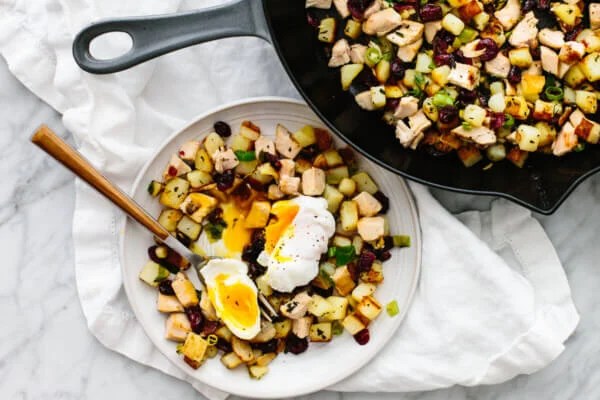 A serving of turkey cranberry hash on a plate with poached egg.
